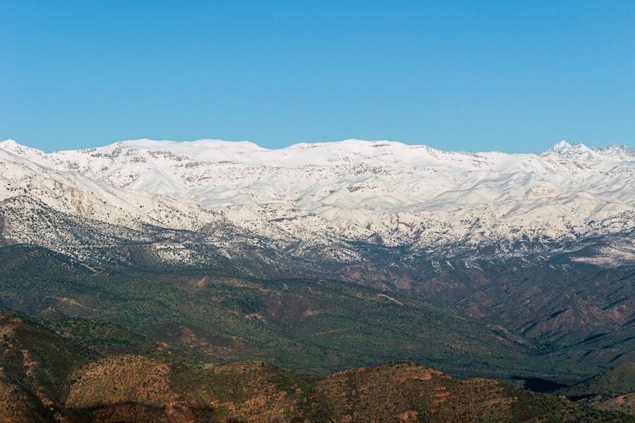 Snow-capped Atlas Mountains against blue sky