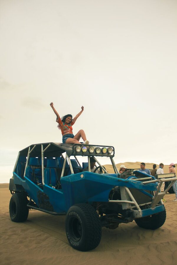 Woman riding dune buggy in desert