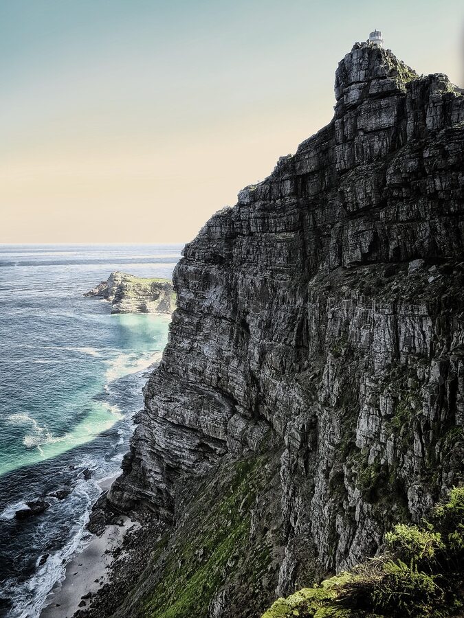 Cape Point lighthouse on cliff with ocean