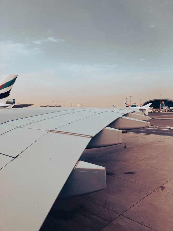 Airplane wing at Dubai Airport during sunset