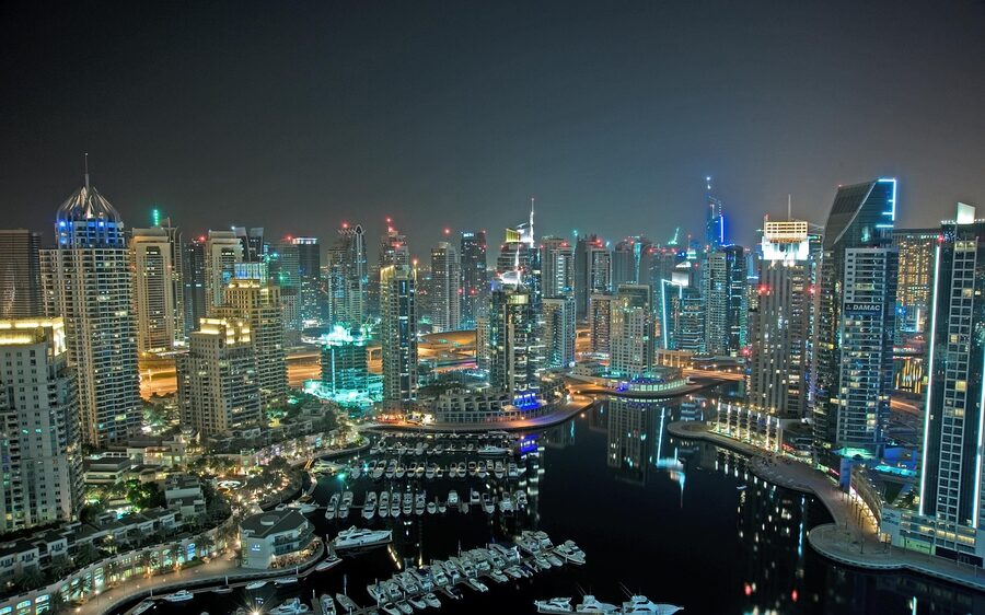 Dubai Marina at night with illuminated buildings reflected in water