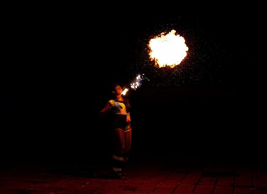 Fire dancer performing with flames at night