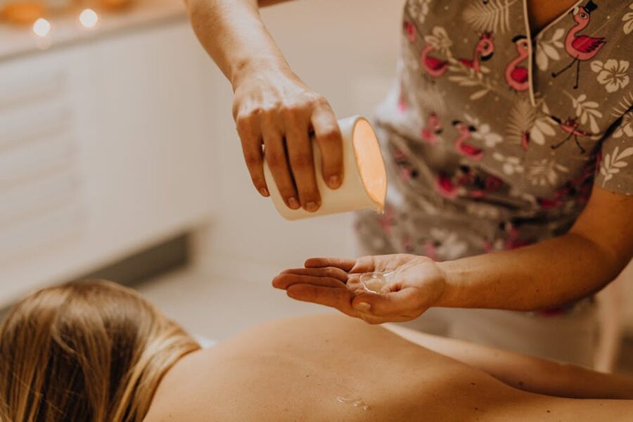 Spa therapist pouring massage oil