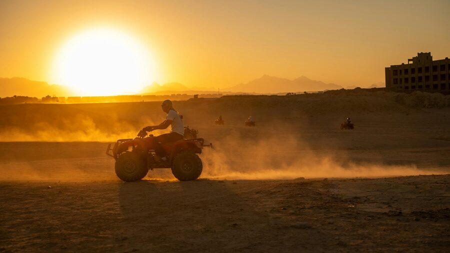 ATV riders exploring the desert at sunset