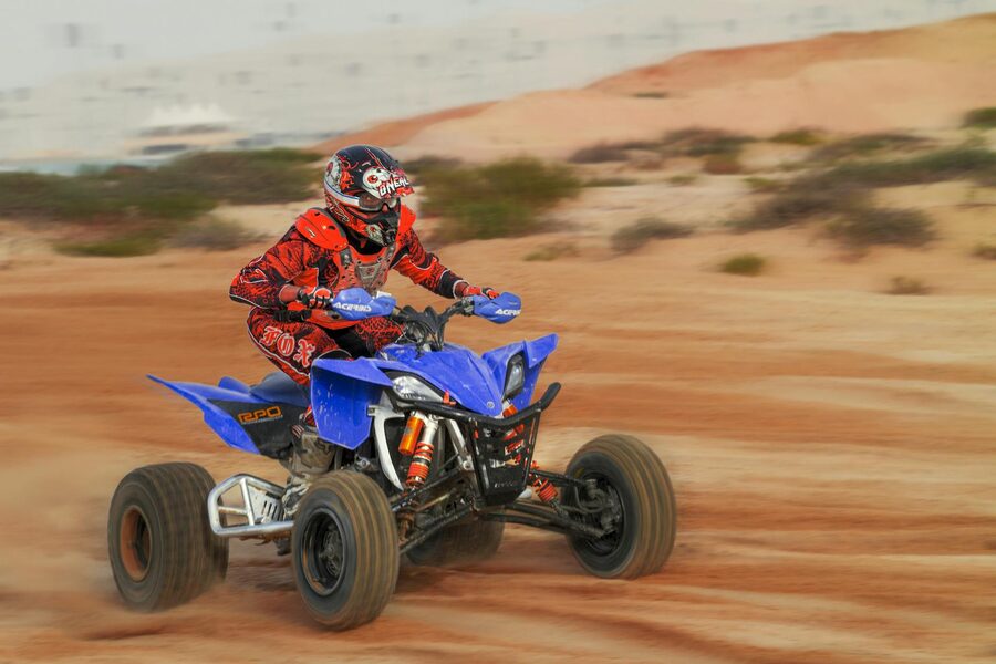 Rider maneuvering a quad bike through desert terrain