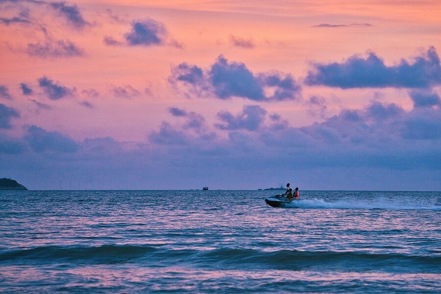 Jet ski silhouette against sunset on ocean water