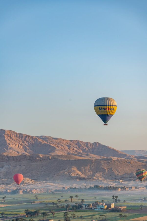 Hot air balloons above desert landscape in Egypt during morning flight