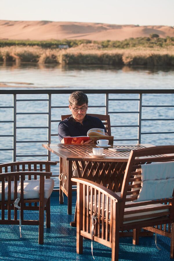 Man reading on a cruise deck overlooking the Nile