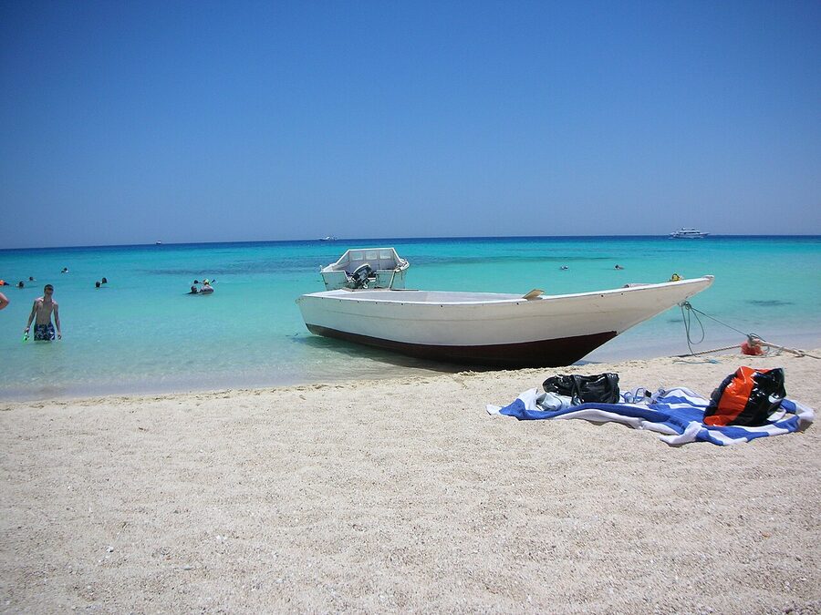 White sand beach at Giftun Island with clear shallow water and tourist boats anchored offshore