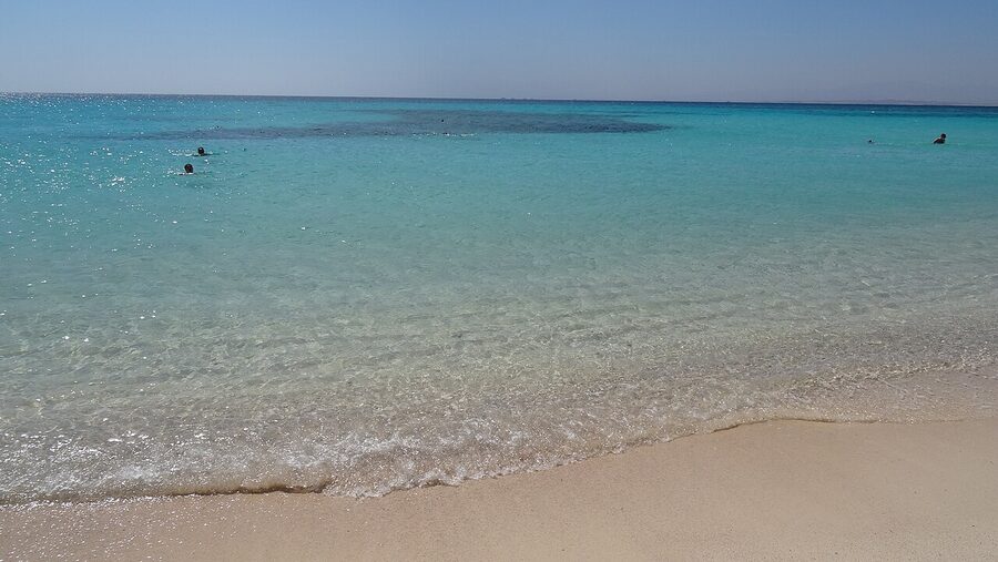 Snorkel boat anchored off Giftun Island with clear Red Sea water and rocky shoreline