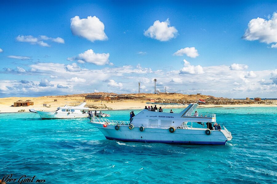 Paradise Island sandbar with small umbrella shelters and turquoise Red Sea water