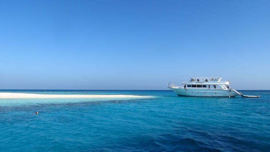 White yacht anchored near Giftun Island with clear water and rocky shore