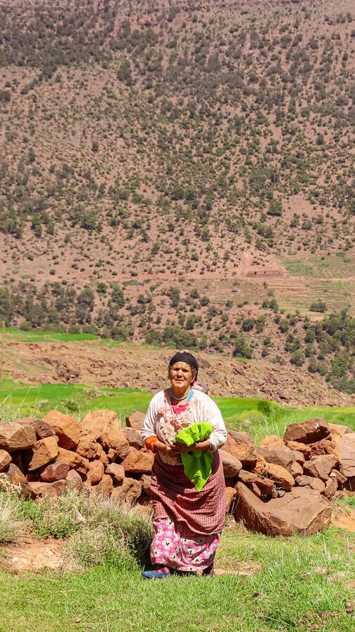 Woman by stone wall with greenery Atlas Mountains