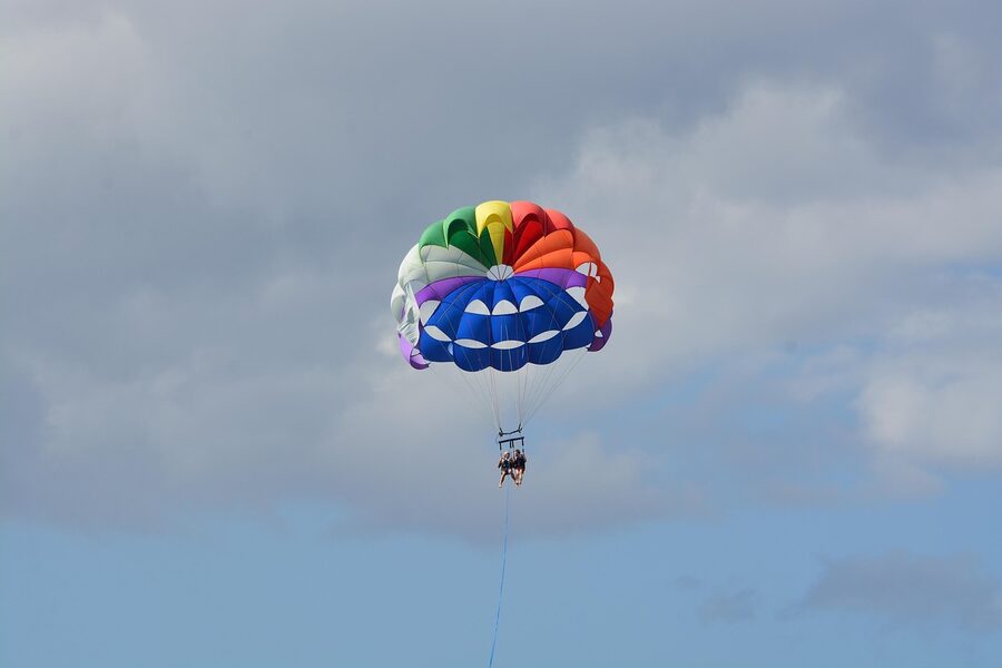 Parasailing sport with colourful parachute over sea
