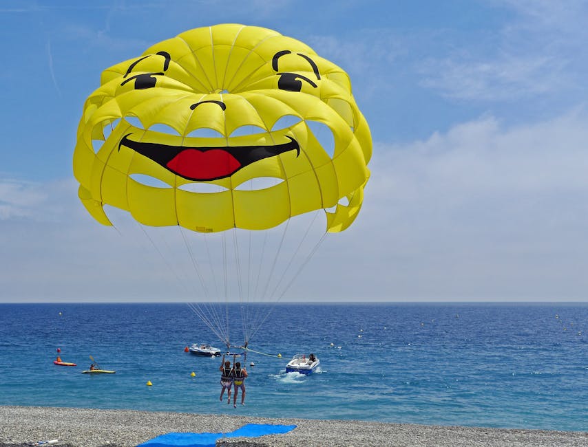 Parasailing with smiley face parachute over blue water