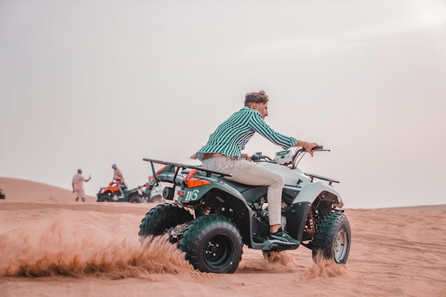 Man on ATV across desert sands
