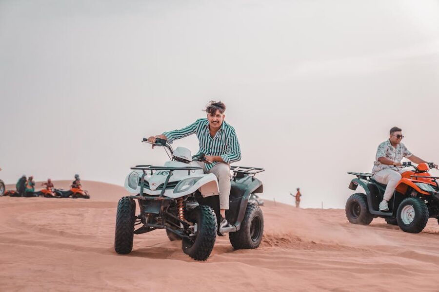 Quad biking sunlit desert dunes