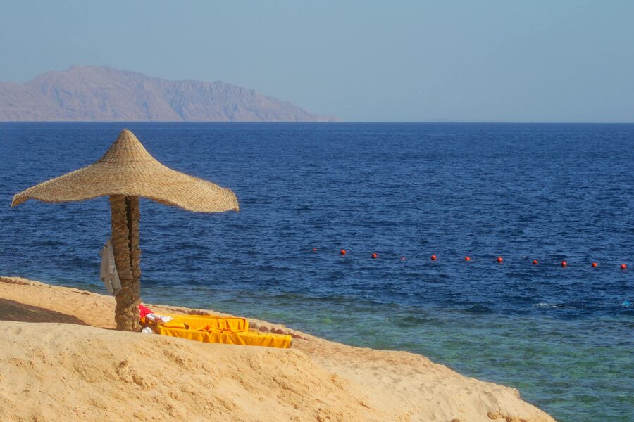Beach with parasol and sandy shore