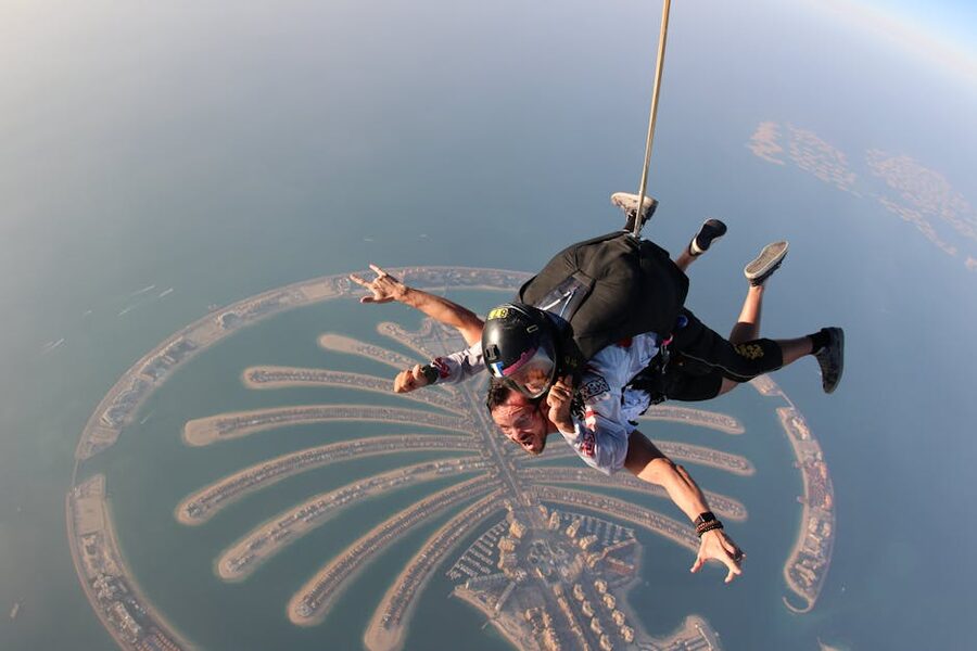 Tandem skydiver above Palm Jumeirah with coastline visible below