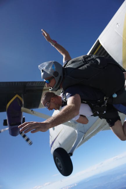 Tandem skydivers preparing to exit aircraft during skydive