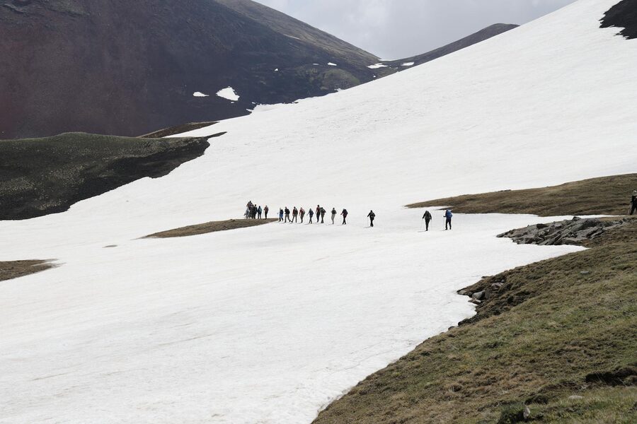 Hikers crossing snow-covered mountain