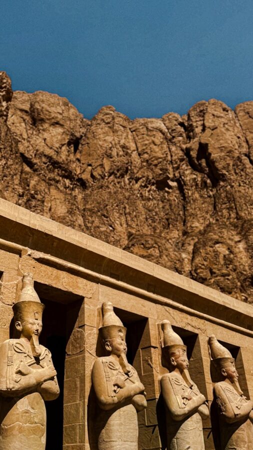 Luxor Temple statues with rocky cliffs