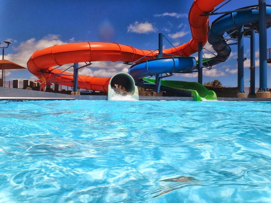 Waterslide ending in splash pool with excited riders
