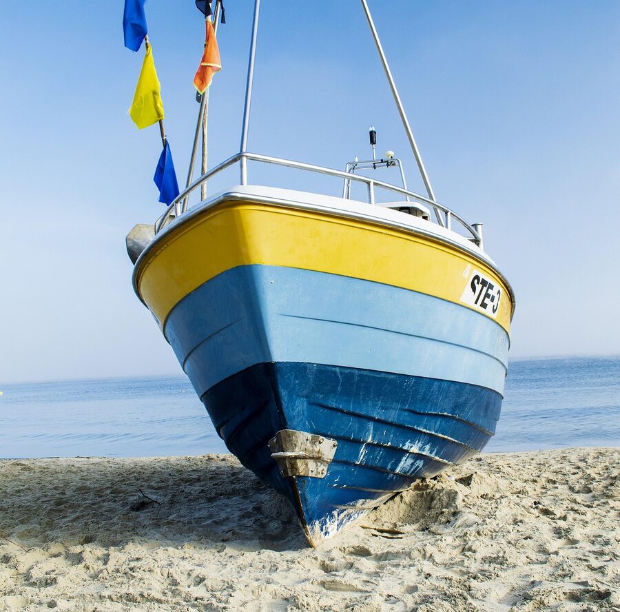 Yacht bow pointing toward ocean horizon with blue sky